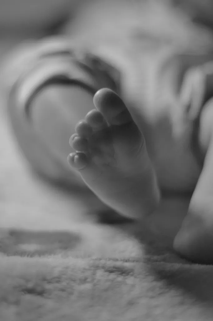 A baby’s foot resting on a blanket